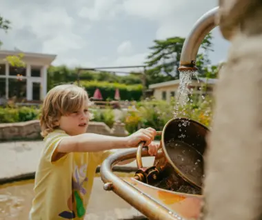 spelen bij de fontein met water en zand jongetje