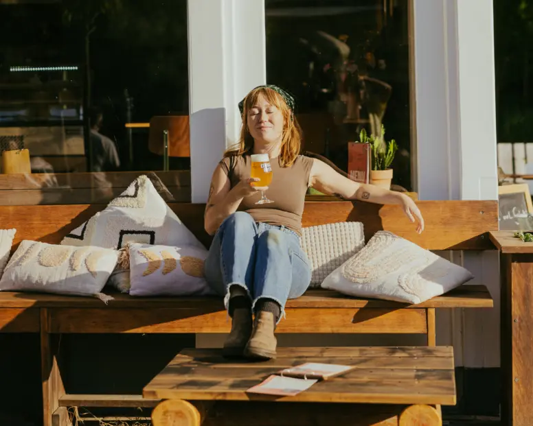 brouwerij de eeuwige jeugd biertje van de tap op het terras in de zon vrouw