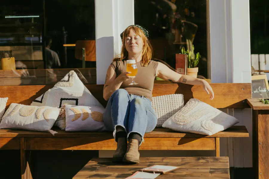 brouwerij de eeuwige jeugd biertje van de tap op het terras in de zon vrouw